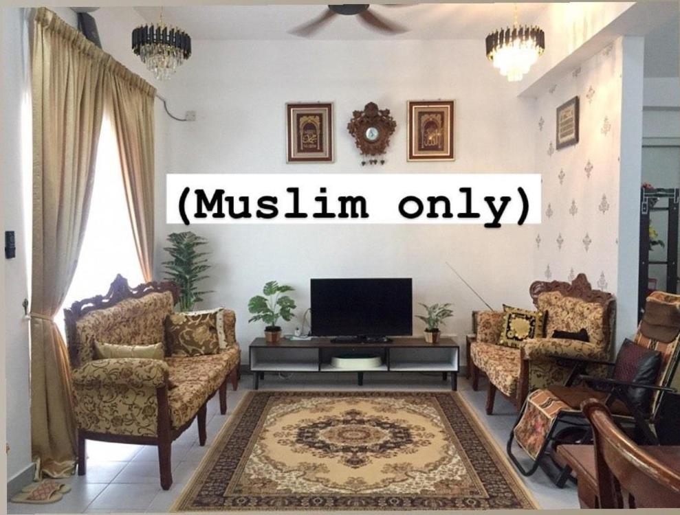 uma sala de estar com uma televisão e um sofá e cadeiras em Hulu Yam Musliim Homestay em Batang Kali