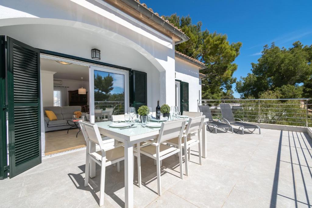 a white dining table and chairs on a patio at Apartamento Minerva in Alcudia