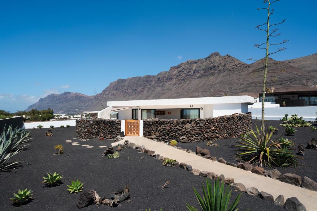 a house with a mountain in the background at LANZAROTE FAMARA BEACH BUNGALOW in Famara