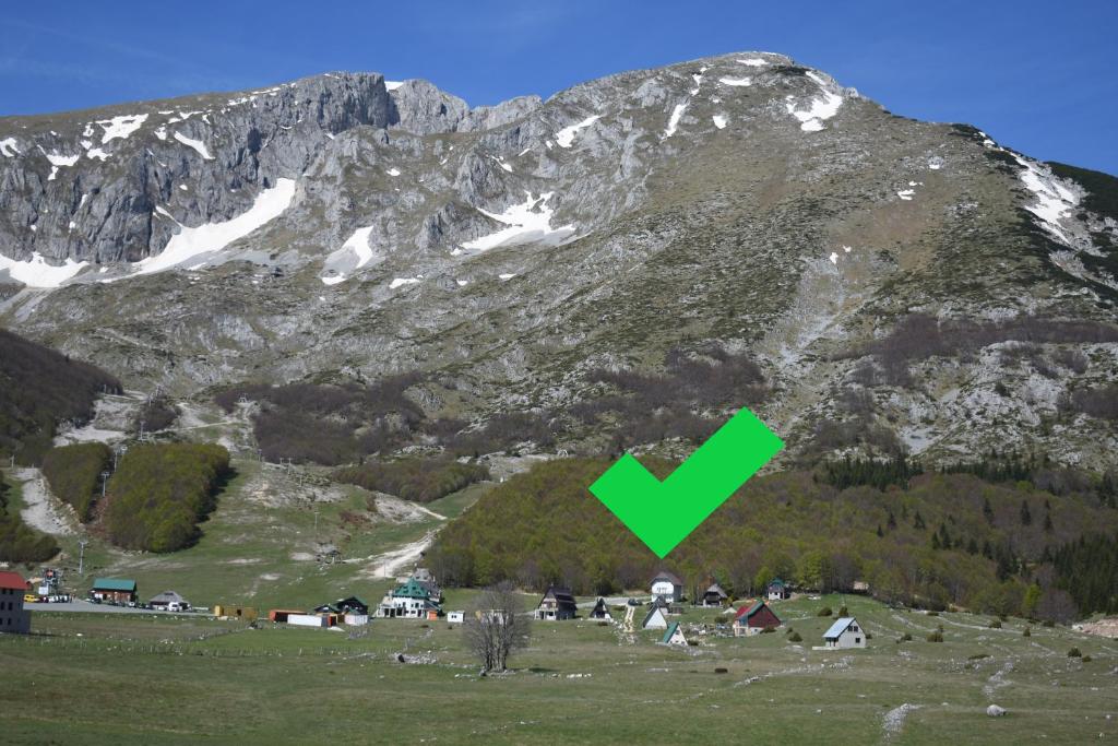 una montaña con una flecha verde apuntando a un pueblo en Rooms Savin kuk view, en Žabljak