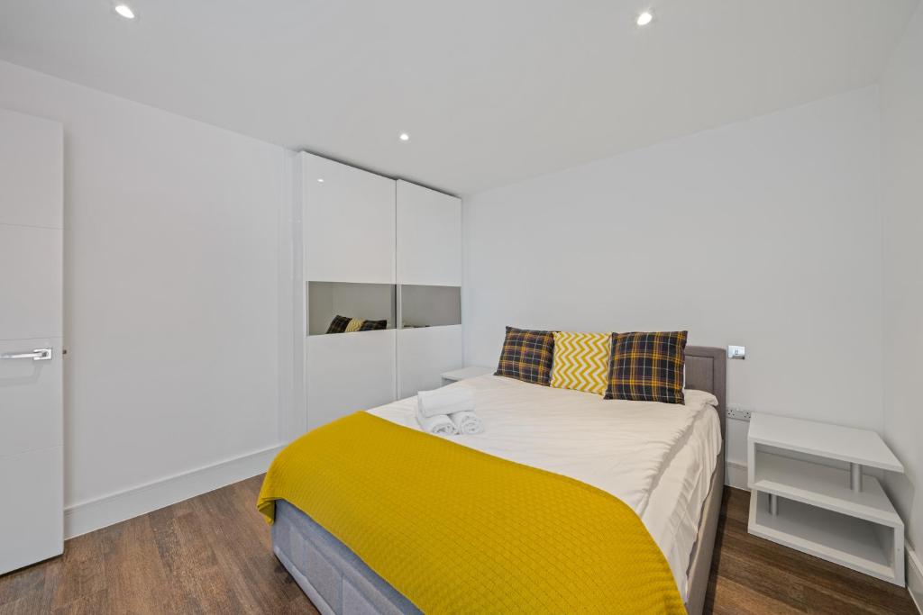 a bedroom with a bed with a yellow blanket at Spacious Modern 1-Bedroom Flat in Central London in London