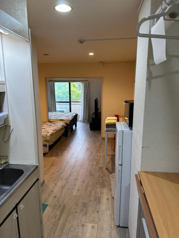 een kamer met 2 bedden en een keuken bij ワイズパーク向島 in Tokyo