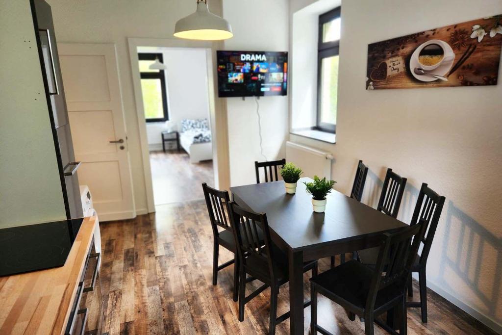 シュトルベルクにあるVoll-Ausgestattete Monteurunterkünfteの黒いテーブルと椅子のあるダイニングルーム