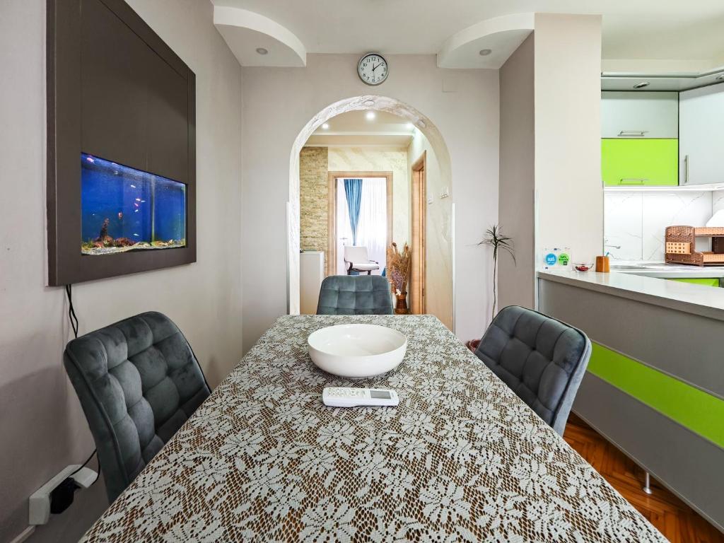 a dining room with a table and chairs and a kitchen at Apartman Julija in Donji Milanovac