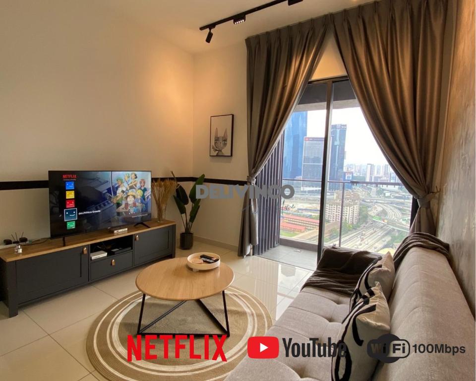 a living room with a couch and a tv at Continew Residensi 2bedroom for 5pax with TRX View in Kuala Lumpur