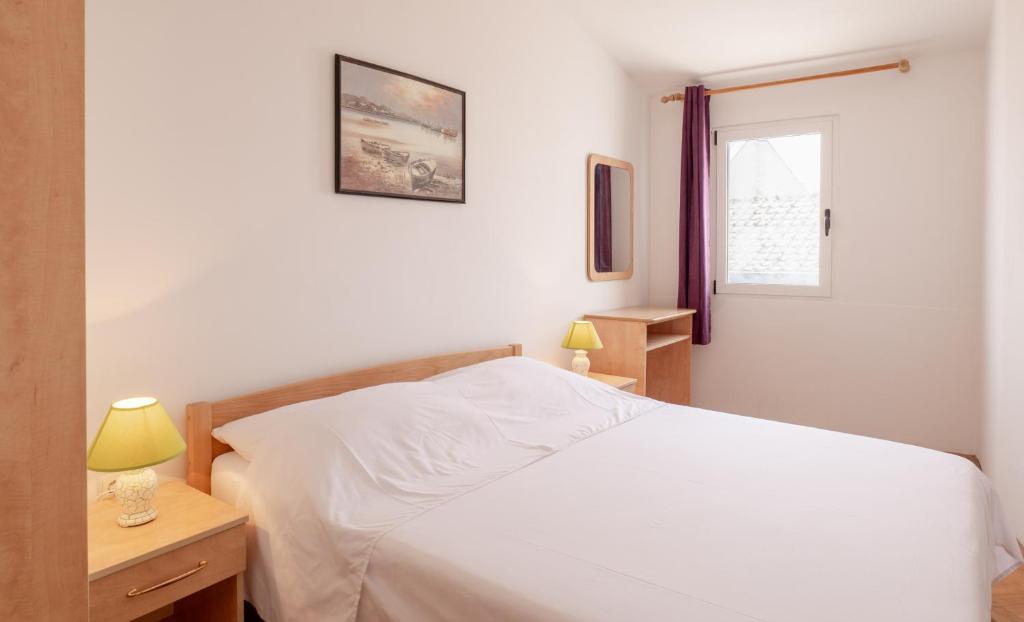 1 dormitorio con cama blanca y ventana en Apartments Center Pag 50 m to the sea, en Pag