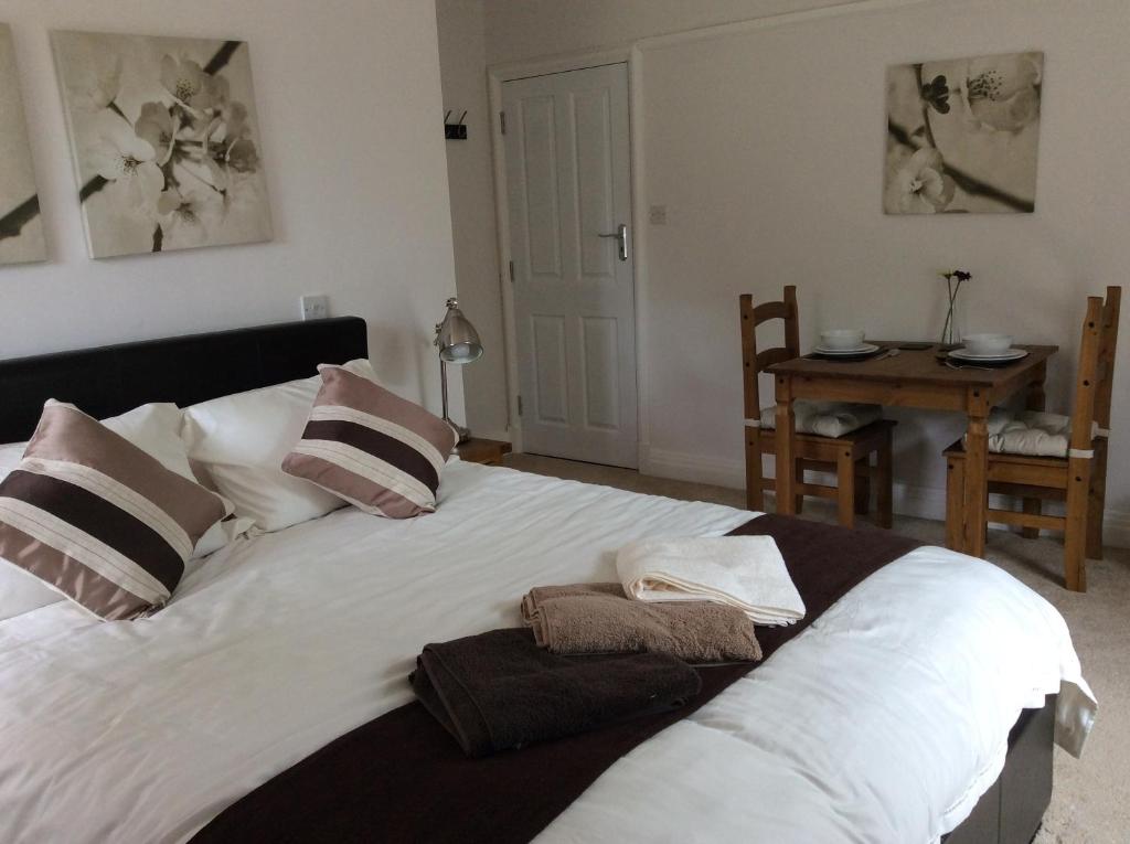 a large white bed with pillows and towels on it at Beightons Bed and Breakfast in Bury Saint Edmunds