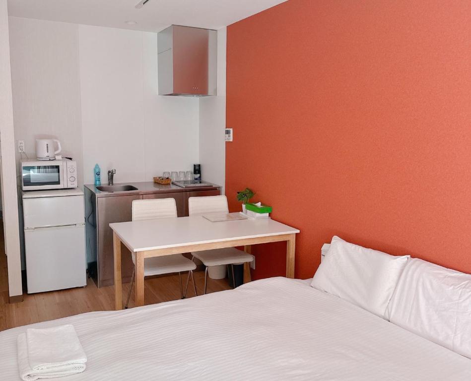 Cet appartement comprend une chambre avec un lit et une table ainsi qu'une cuisine. dans l'établissement 難波民泊501, à Osaka
