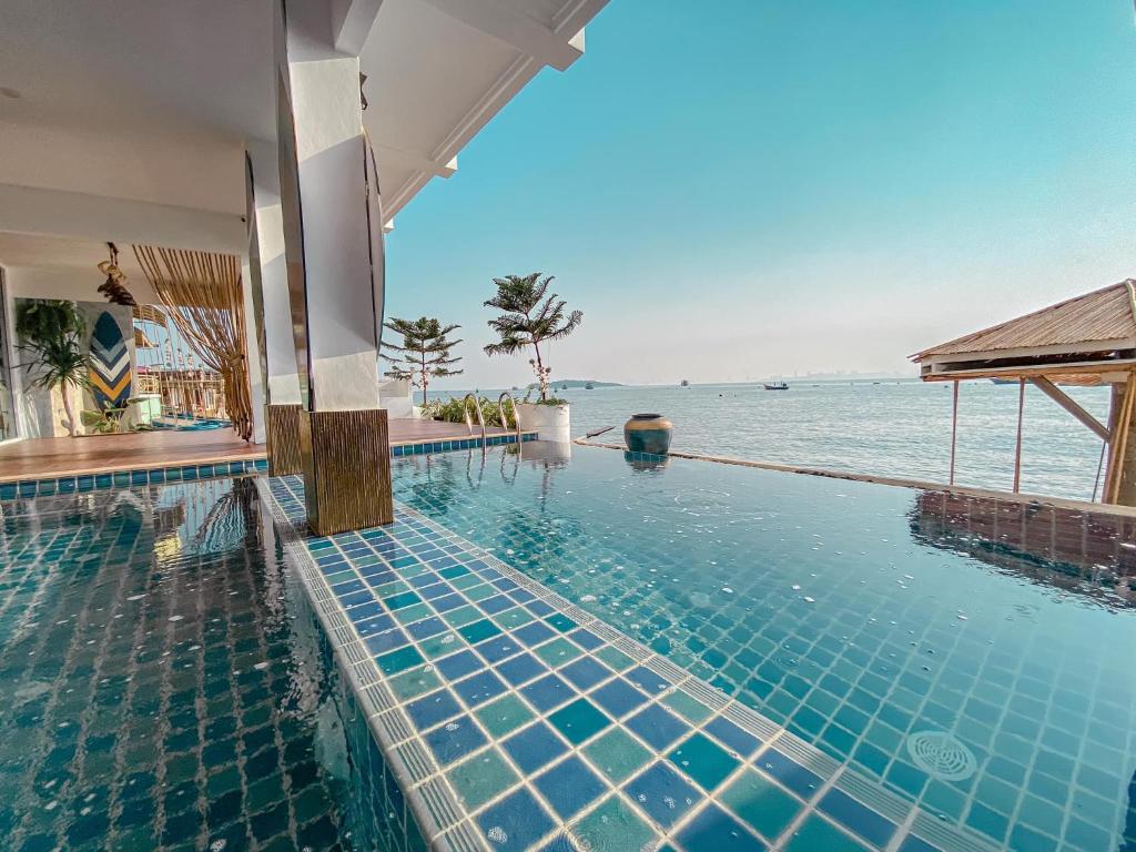 a swimming pool with a view of the ocean at Baan Sailboat Beach Kohlarn in Ban Kraek