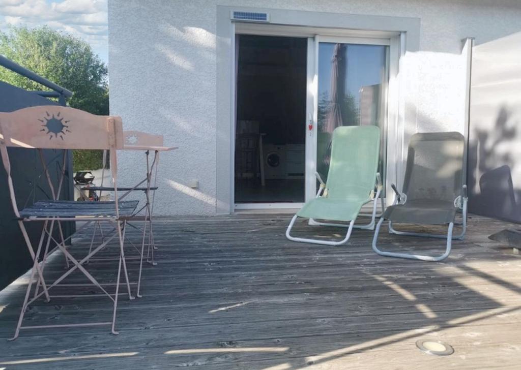 2 sillas y una mesa en el patio en Maison d'une chambre avec jardin amenage et wifi a Yssingeaux a 3 km des pistes, en Yssingeaux
