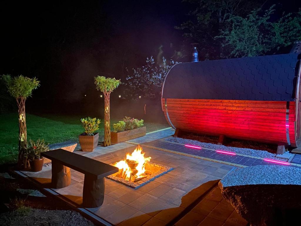 a fire pit in a backyard with a bench and a fire pit at Domek pod Lasem na Mazurach in Ryn