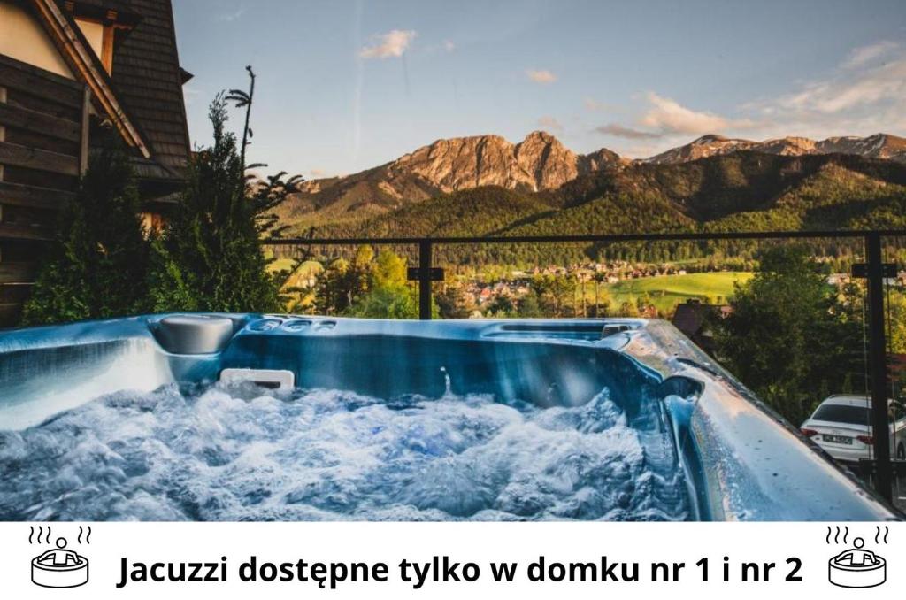a jacuzzi tub with a view of the mountains at Czarne Wierchy Domy Premium in Kościelisko