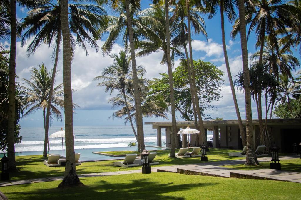 een resort met palmbomen en de oceaan bij Kelapa Retreat & Spa in Pulukan