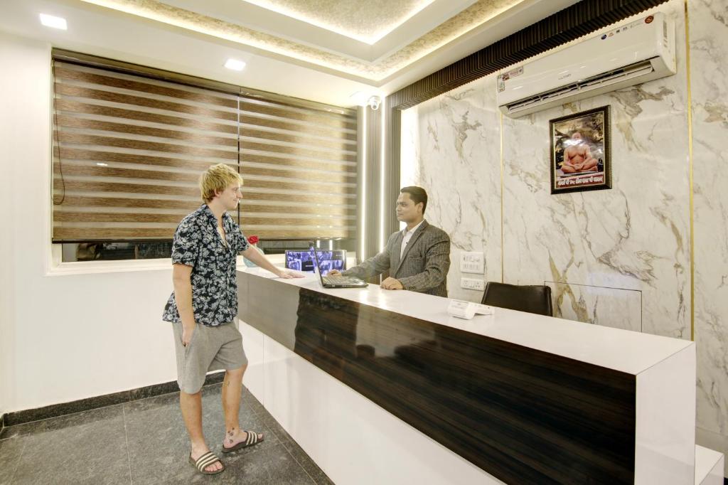 a man and a woman standing at a reception desk at Hotel Devrana Delhi in New Delhi