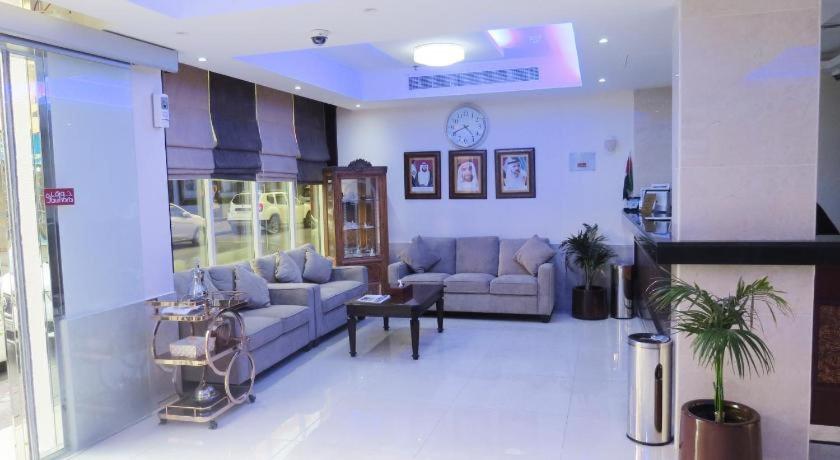 a living room with couches and a clock on the wall at Metro Single beds boys room next to Union Metro Station in Dubai