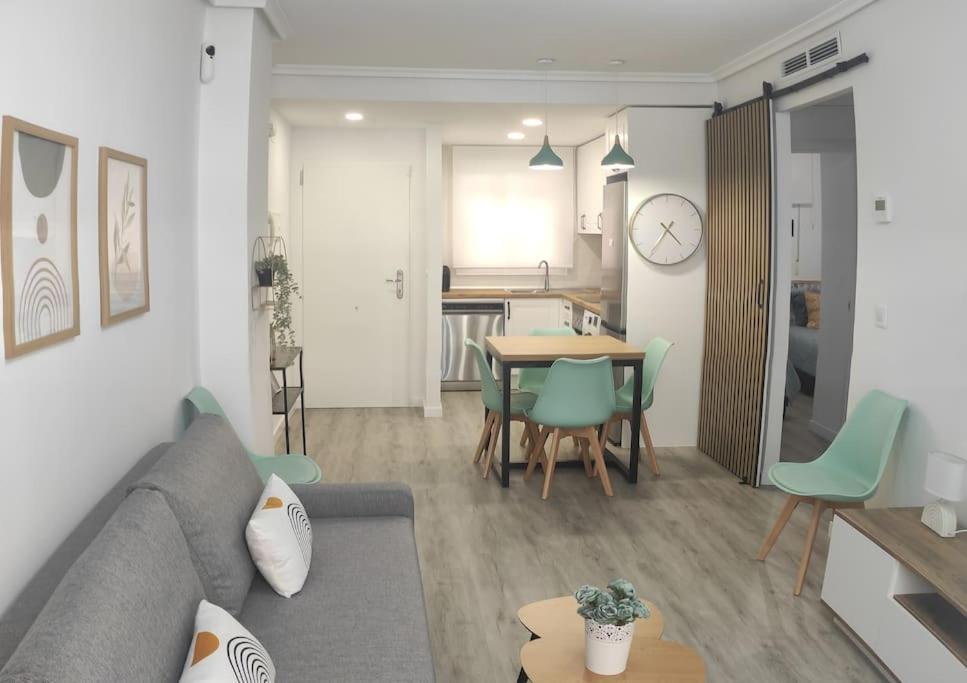 ein Wohnzimmer mit einer Couch und einem Tisch mit Stühlen in der Unterkunft Marina Golden Choice - Piso nuevo a 350m playa in Oropesa del Mar