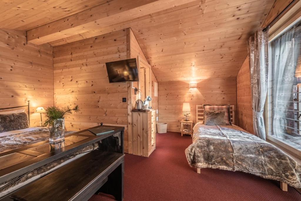 Chalais的住宿－Les Mazots du Victoria，木制客房内的一间卧室配有两张床