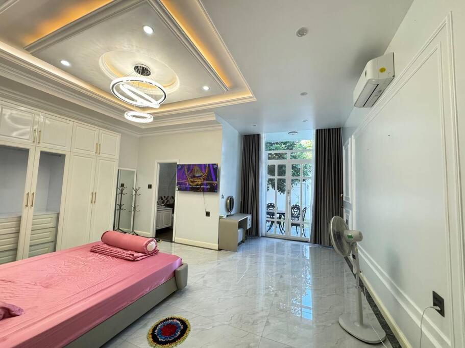 1 dormitorio con 1 cama rosa en una habitación en Villa for rent in Tra Vinh City en Xóm Vàng