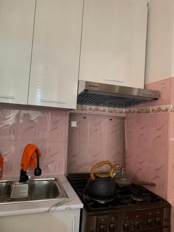 cocina con armarios blancos y fogones en Cozy apartment in Samarkand, en Samarkand