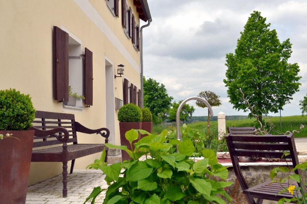 a patio with benches and plants and a building at Ferienwohnung Hoacherer-Hof in Riedenburg
