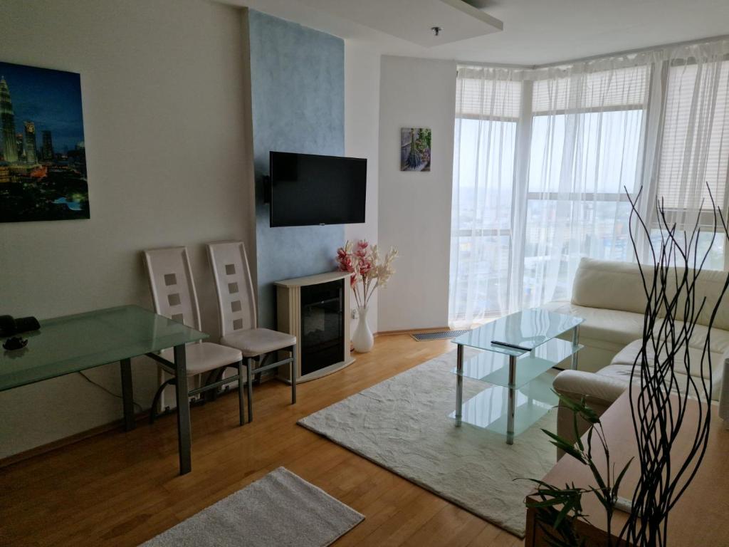 a living room with a couch and a table at apartmán 21-th floor Bratislava Petrzalka (building Vienna Gate) in Bratislava
