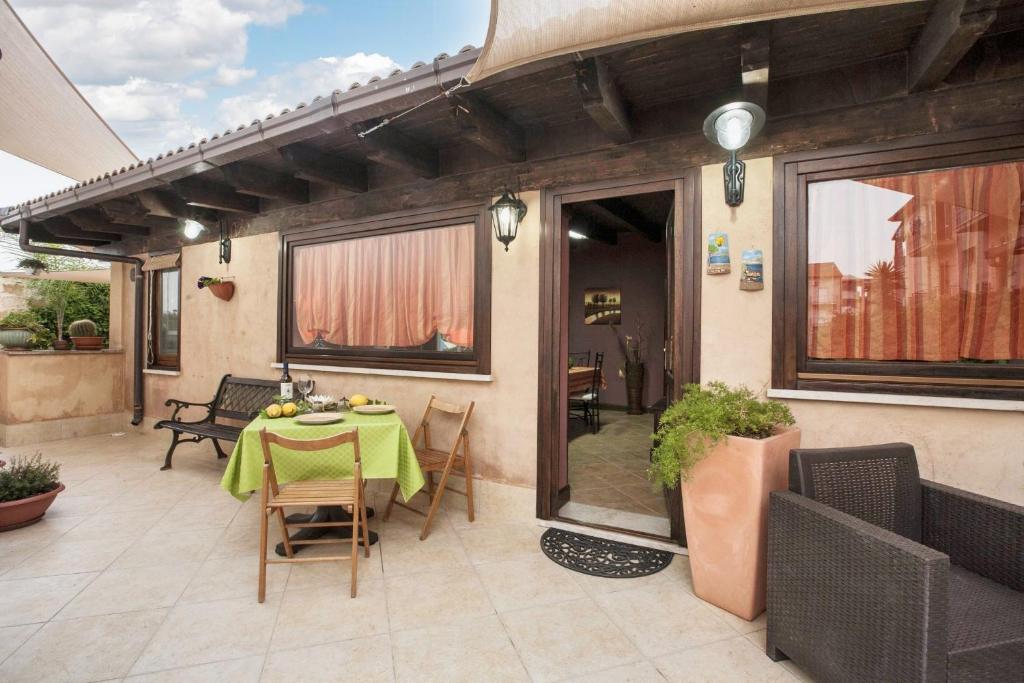 een patio met een tafel en stoelen bij One bedroom house with enclosed garden and wifi at Castellammare del Golfo 2 km away from the beach in Castellammare del Golfo