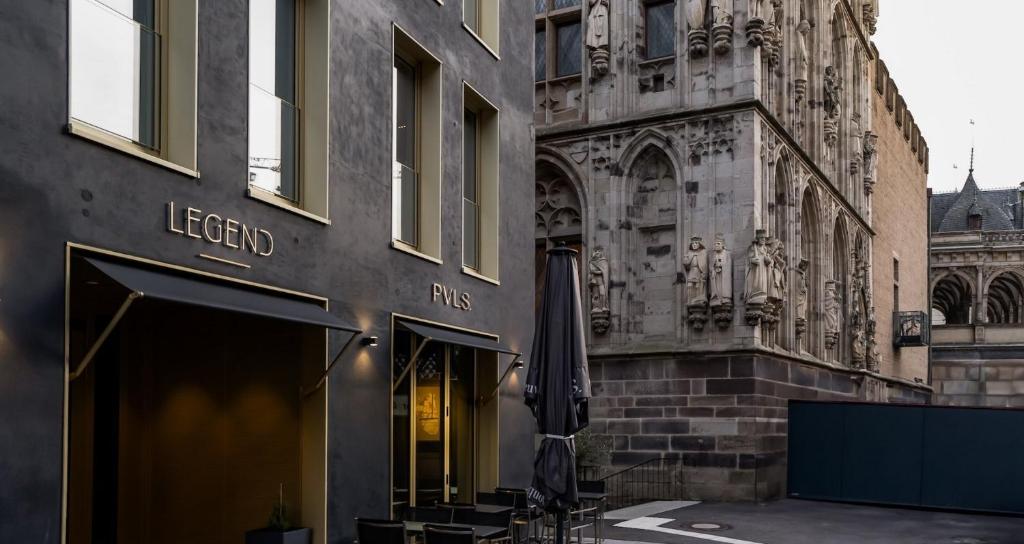 ein Geschäft vor einem Gebäude mit einem Regenschirm in der Unterkunft Legend Hotel in Köln