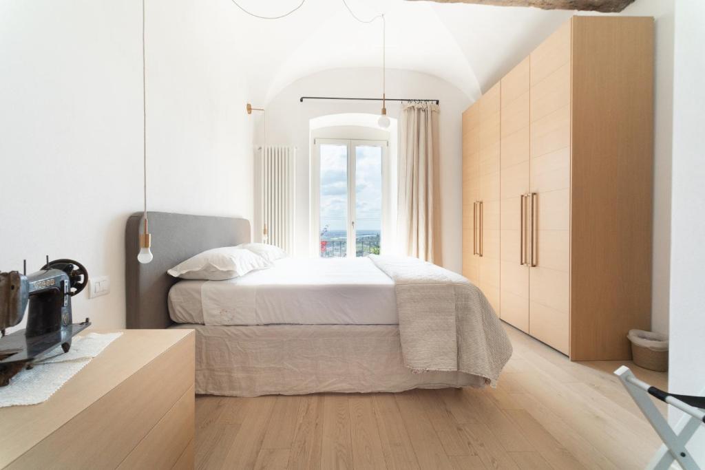 ein Schlafzimmer mit einem großen Bett und einem Fenster in der Unterkunft Il Donizettino in Bergamo