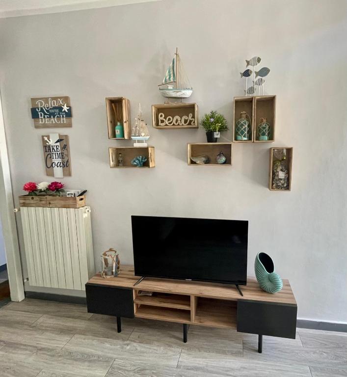 a living room with a flat screen tv on a wall at Brezza Marina in Diano Marina