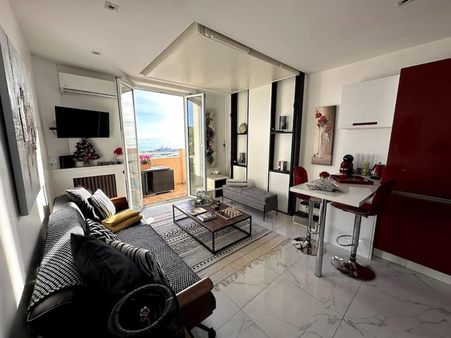 ein Wohnzimmer mit einem Sofa und einem Tisch in der Unterkunft Studio VUE MER IMPRENABLE PLEIN SUD à GOLFE JUAN in Vallauris