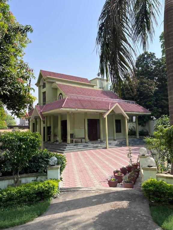 a house with a red tile roof and a driveway at Kusum Villa in Varanasi