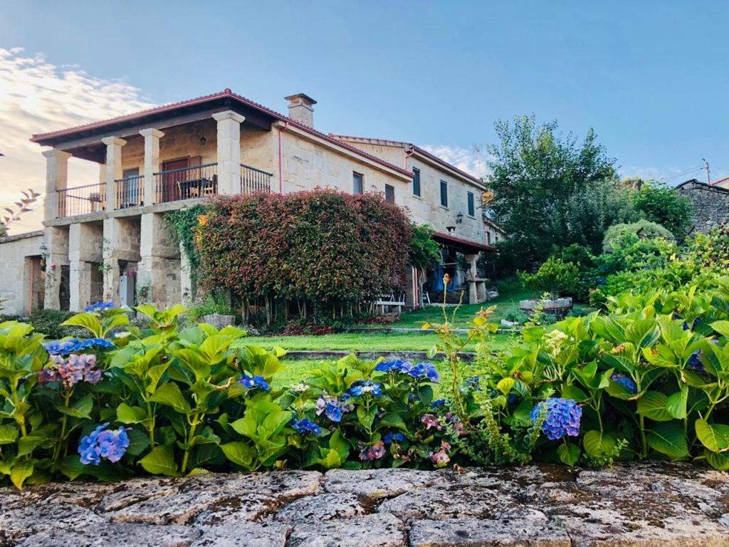 une grande maison avec un jardin en face de celle-ci dans l'établissement Alojamiento Pazos, à Cea