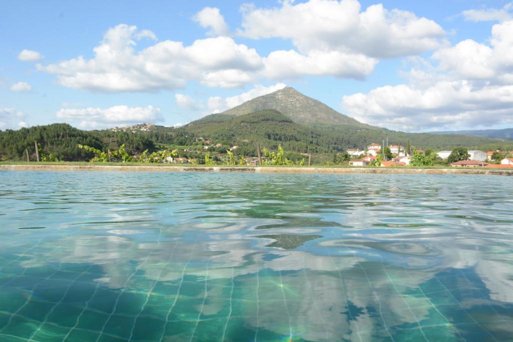 un bacino d’acqua con una montagna sullo sfondo di Quinta do Fundo a Mondim de Basto