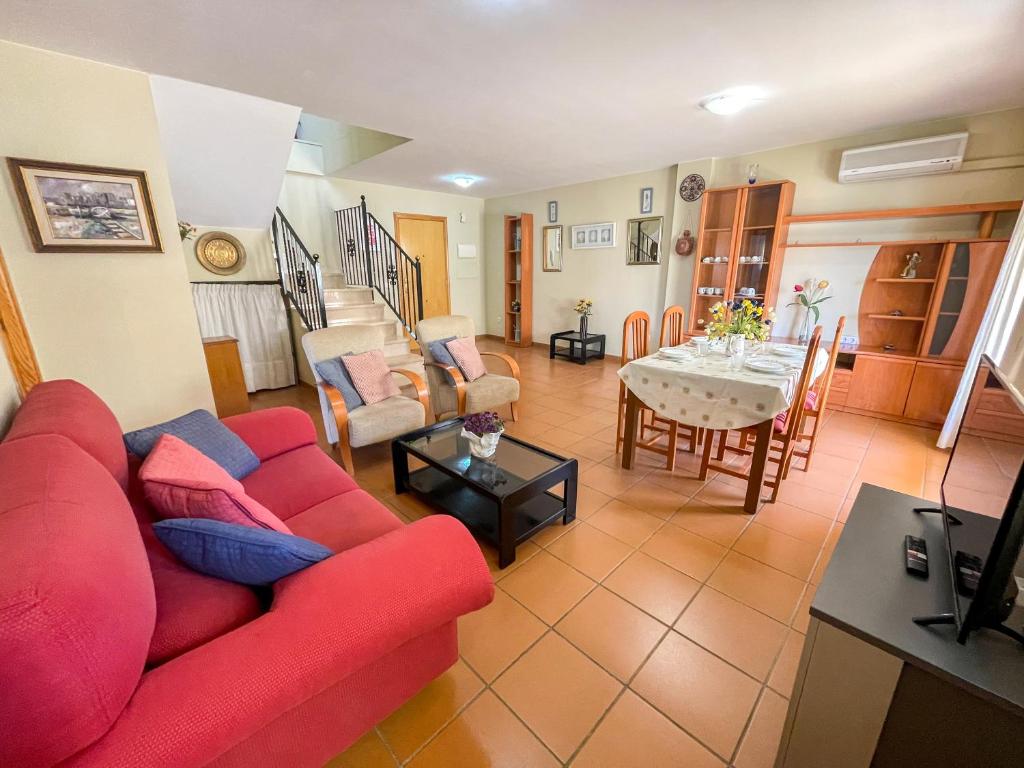 a living room with a red couch and a table at Apartamentos Canet de Berenguer 3000 in Canet de Berenguer