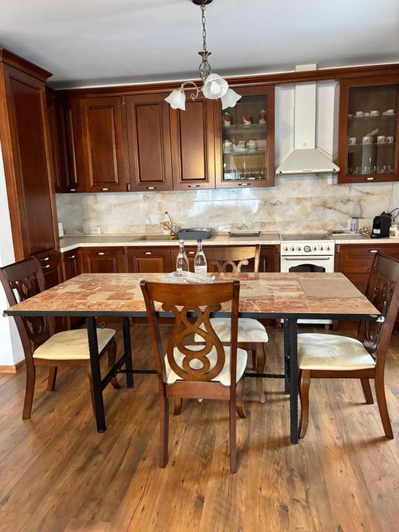 uma cozinha com uma mesa de madeira e cadeiras em Casa Mara em Cristian