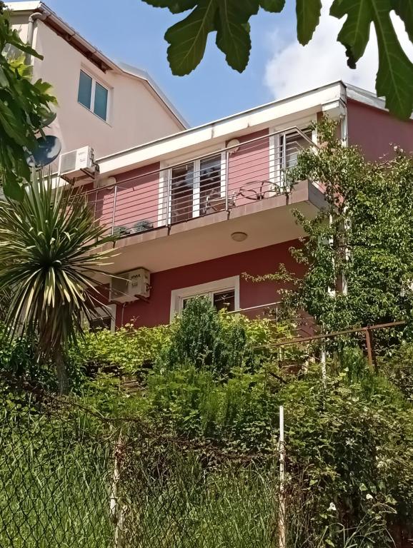 una casa con una recinzione di fronte di Markovic Apartmani Becici a Bečići