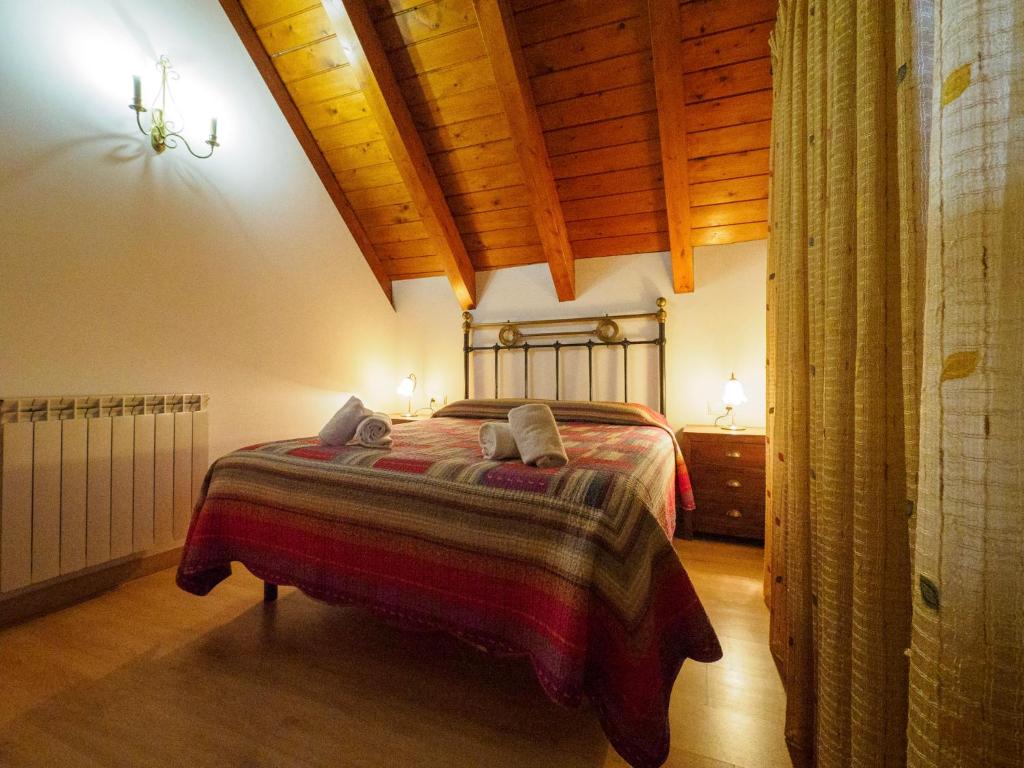 una camera con letto e soffitto in legno di Apartamentos Casa Cecilia a San Juan de Plan