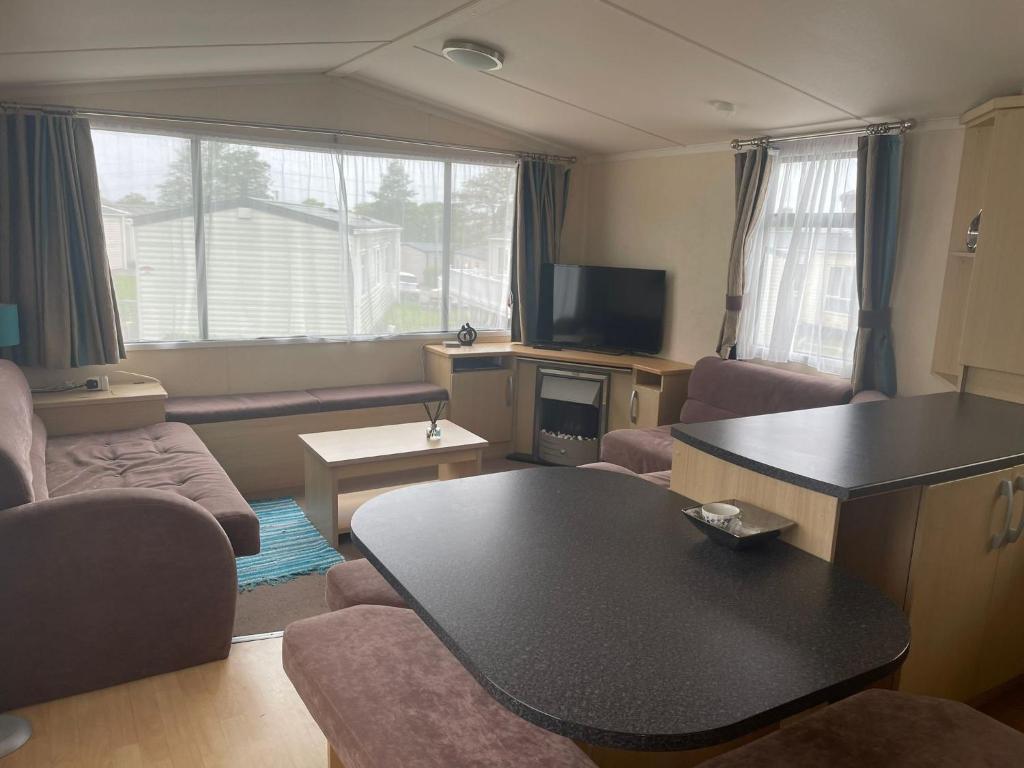 a living room with a table and a couch at Swift Holiday Caravan Rockley Park in Lytchett Minster