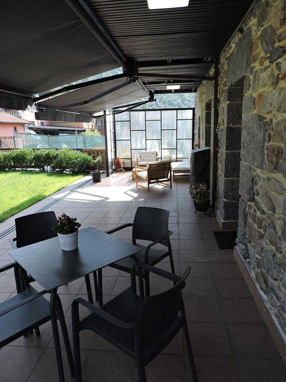 Un patio con mesa y sillas y un muro de piedra. en Casas Piedra, en Arredondo