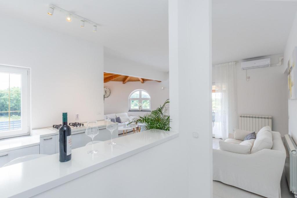 una cucina bianca e un soggiorno con mobili bianchi di Villa Aria private Pool near Vrsar a Vrsar