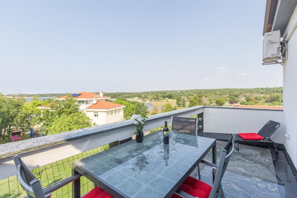 een tafel en stoelen op een balkon met uitzicht bij Bellavista Superior Funtana in Funtana