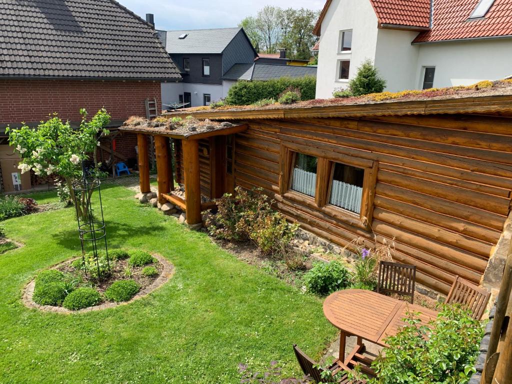 uma cabana de madeira com um banco no quintal em Blockhausvermietung "Vor dem Gröperntor" em Quedlinburg