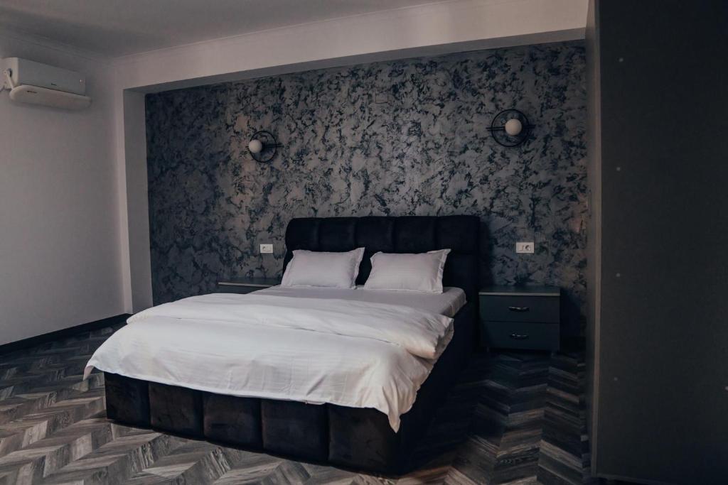 Schlafzimmer mit einem großen Bett mit einem schwarzen Kopfteil in der Unterkunft Pensiunea R&R Băilești in Băileşti