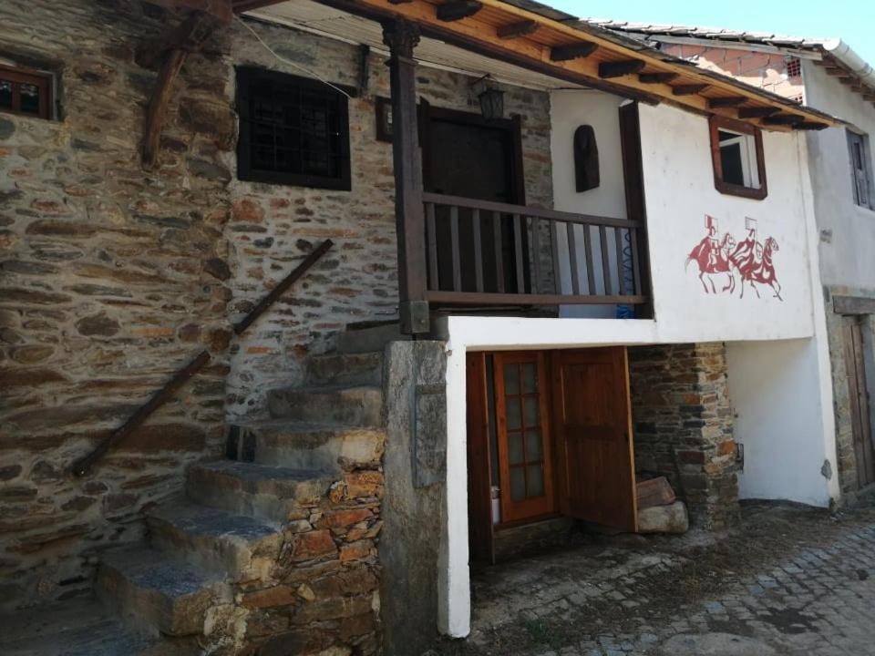a stone building with a door and a balcony at Casal de Palácios- França in Bragança
