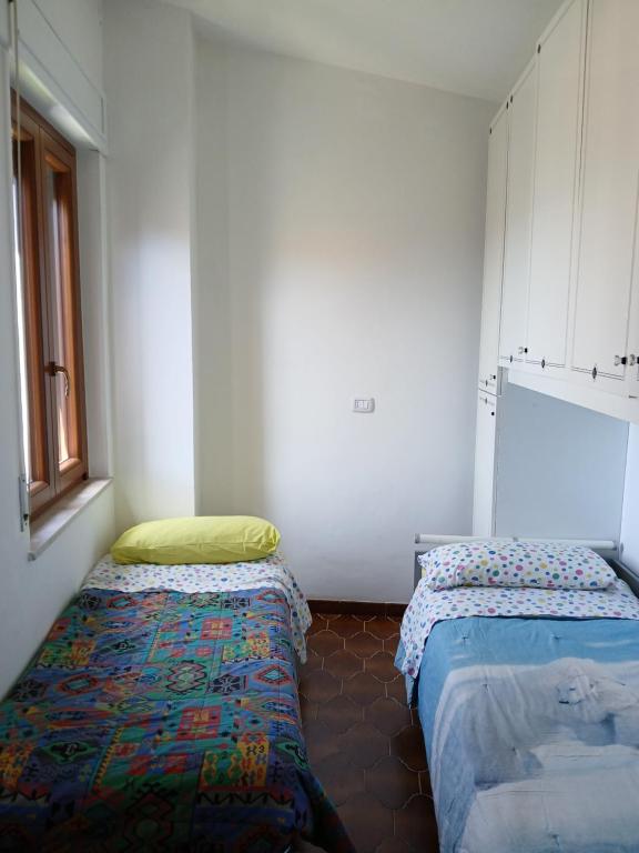 Torricella Peligna的住宿－La casetta in montagna，客房设有两张床和窗户。