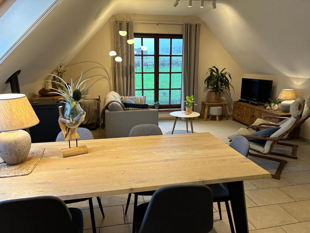 sala de estar con mesa de madera y sillas en Au Coeur des Collines, Gloriette, en Ellezelles