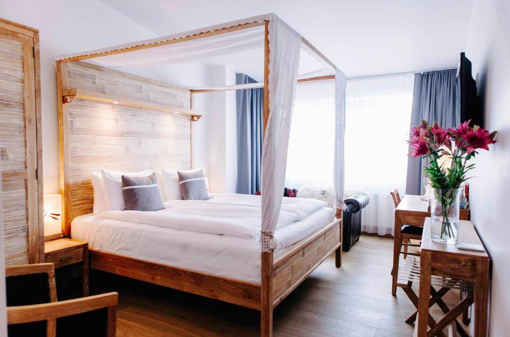 1 dormitorio con cama con dosel y mesa con flores en Eyja Guldsmeden Hotel en Reikiavik