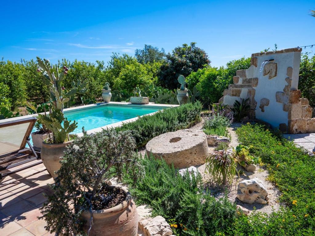 a swimming pool in a garden with plants at Country house La Virgy with exclusive pool and sea view in Avola