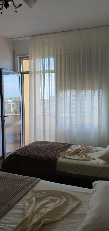 um quarto com 2 camas e uma janela em City Center Apartment em Shkodër