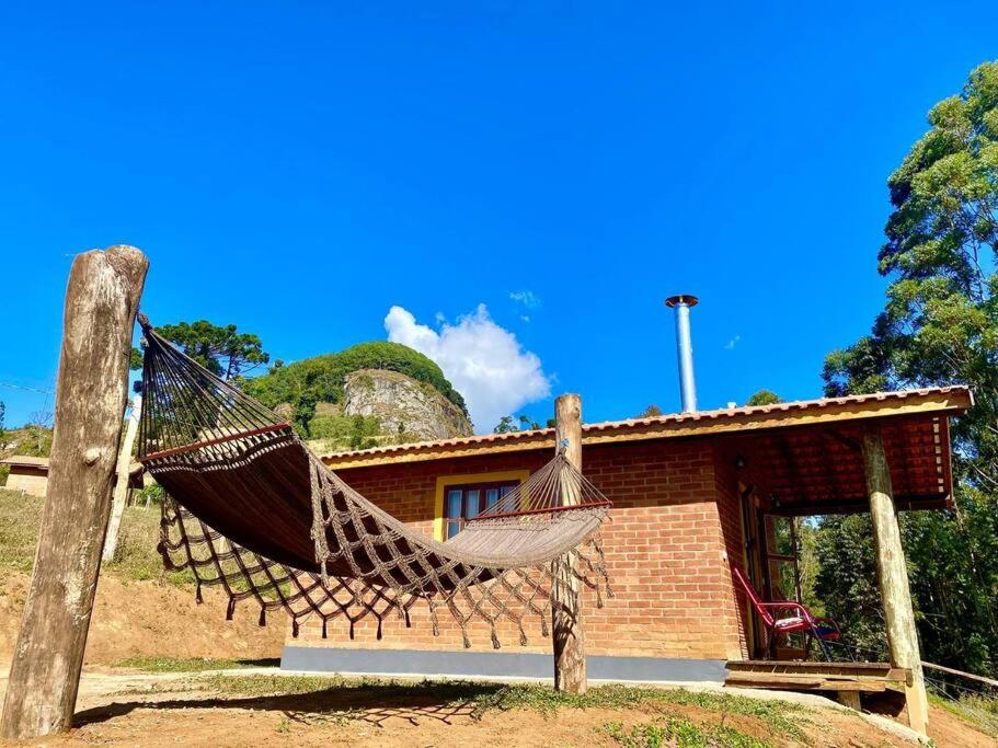 una hamaca frente a una casa en Chalé Pedra Chanfrada 02, en Gonçalves